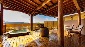 A wooden deck with a hot tub and chairs, overlooking a scenic landscape. - Fujiya Ryokan (Kaga)