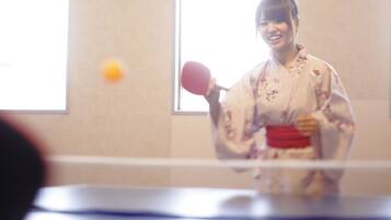 A person in traditional attire playing table tennis.