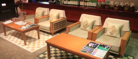 A bar area with seating, a piano, and a television.