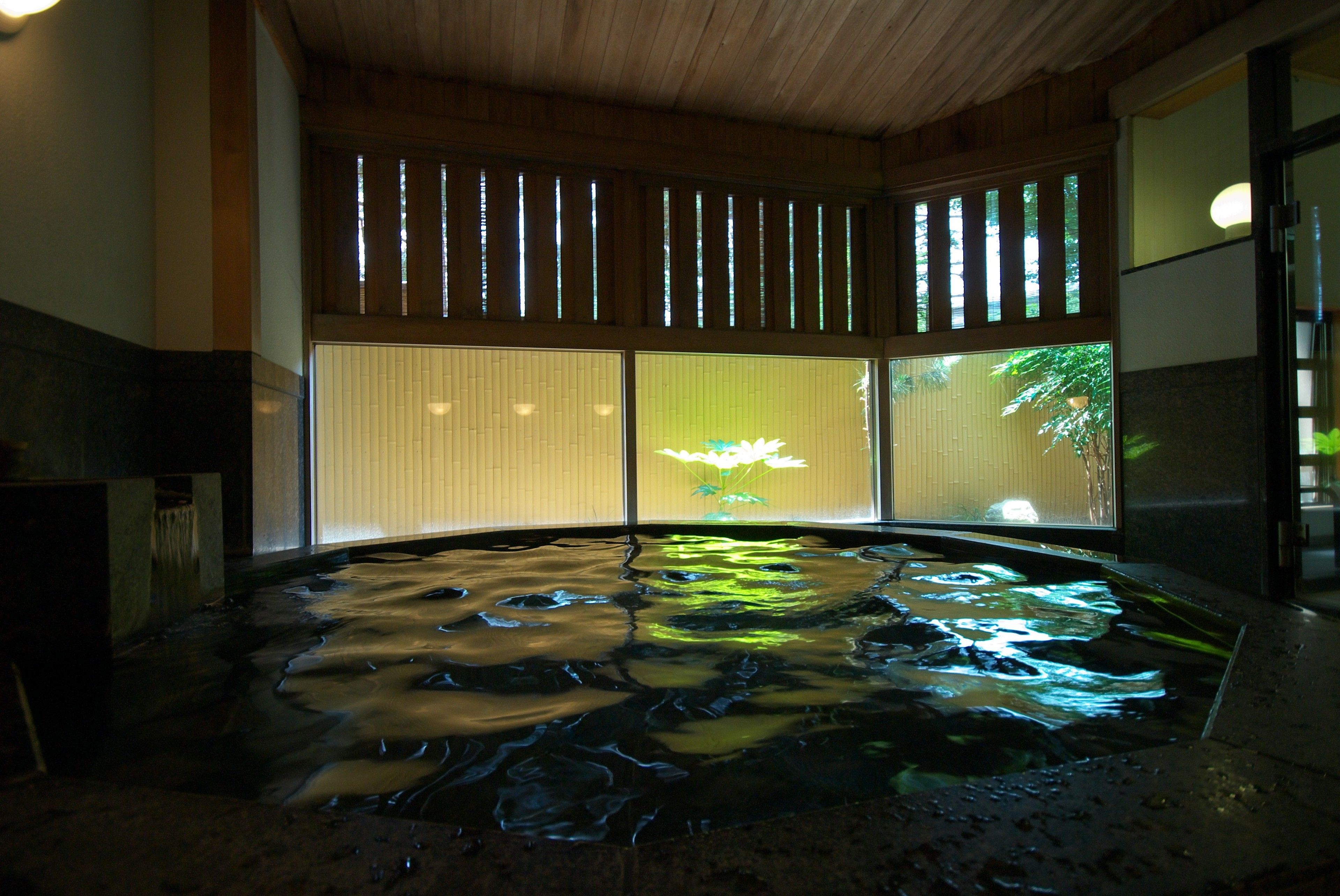 A hot spring bath with wooden beams and sliding doors.