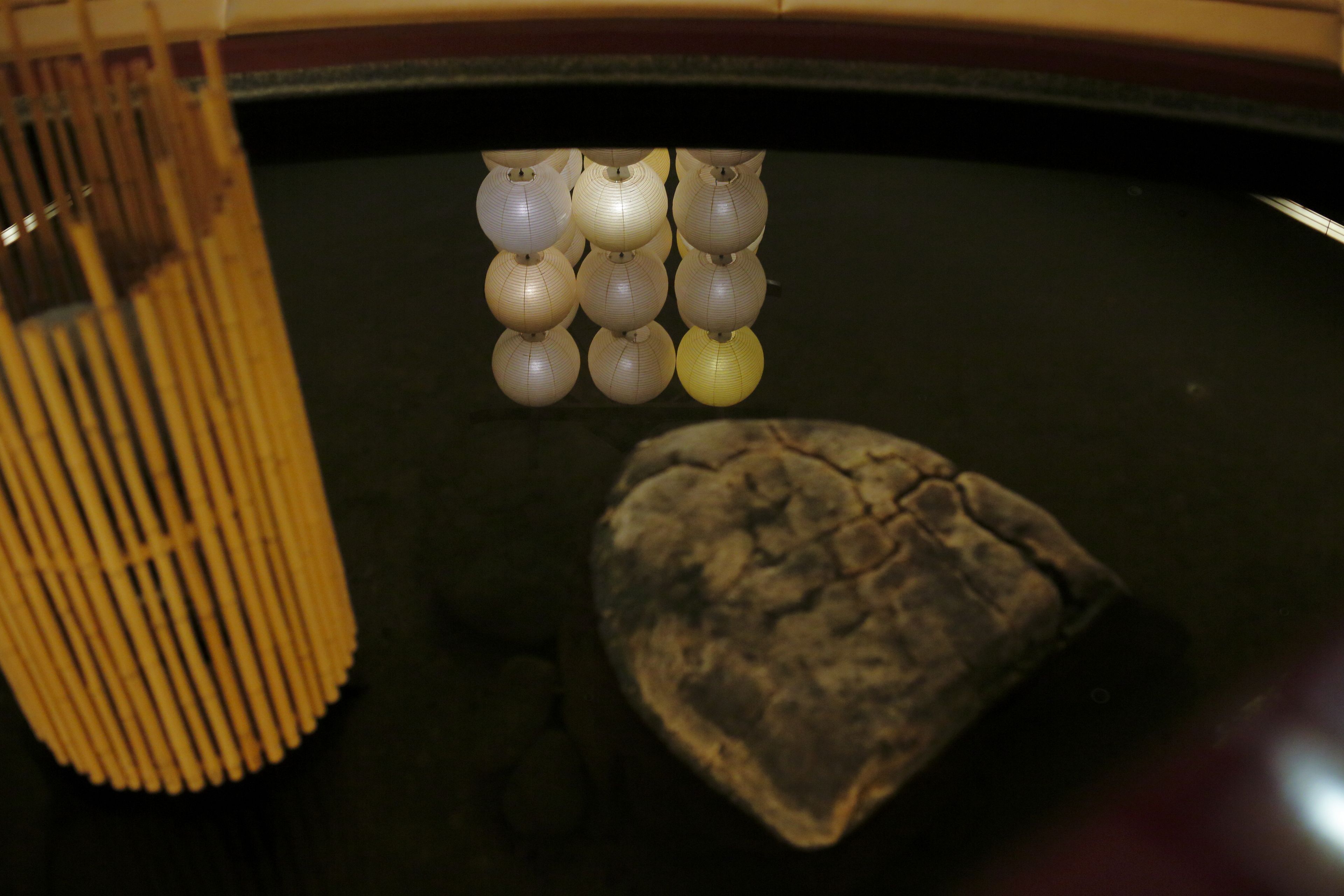 Una mesa de billar con un conjunto de lámparas colgantes y una escultura de piedra.