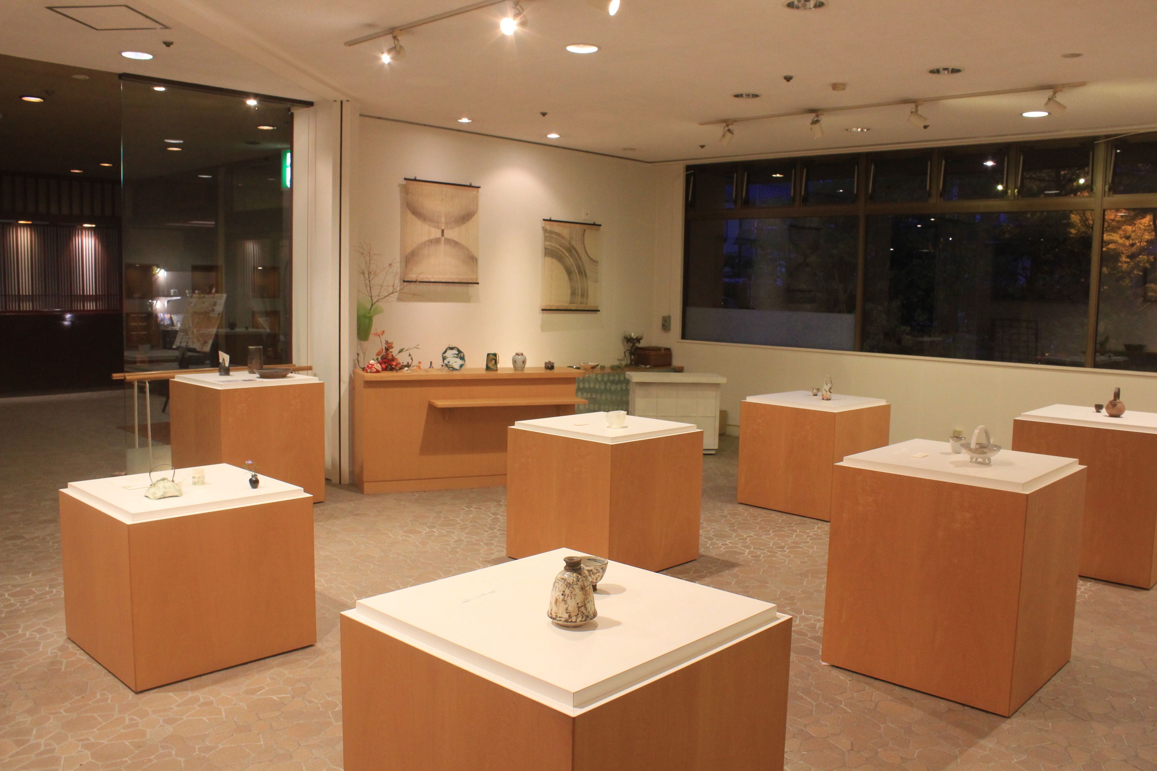 A modern interior with wooden display tables and a large window.