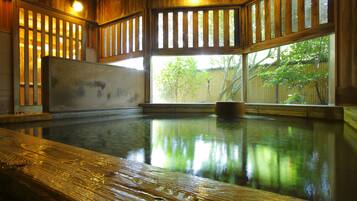 Un interior de madera con un ventanal amplio, un banco de madera y un reflejo en el agua.
