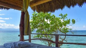 A bed with a view of the ocean and a tree. - The Blue Orchid Resort (Moalboal)