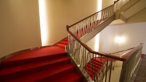A staircase with red carpeted steps and a metal railing. - Meitetsu Toyota Hotel (Toyota)