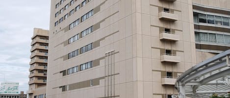 A multi-story hotel with a modern architectural design, featuring a prominent entrance and a balcony on the upper floors.