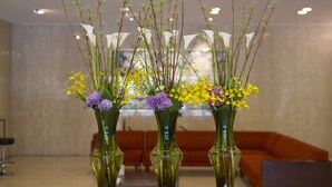 Three vases with flowers in a lobby area. - Meitetsu Toyota Hotel (Toyota)