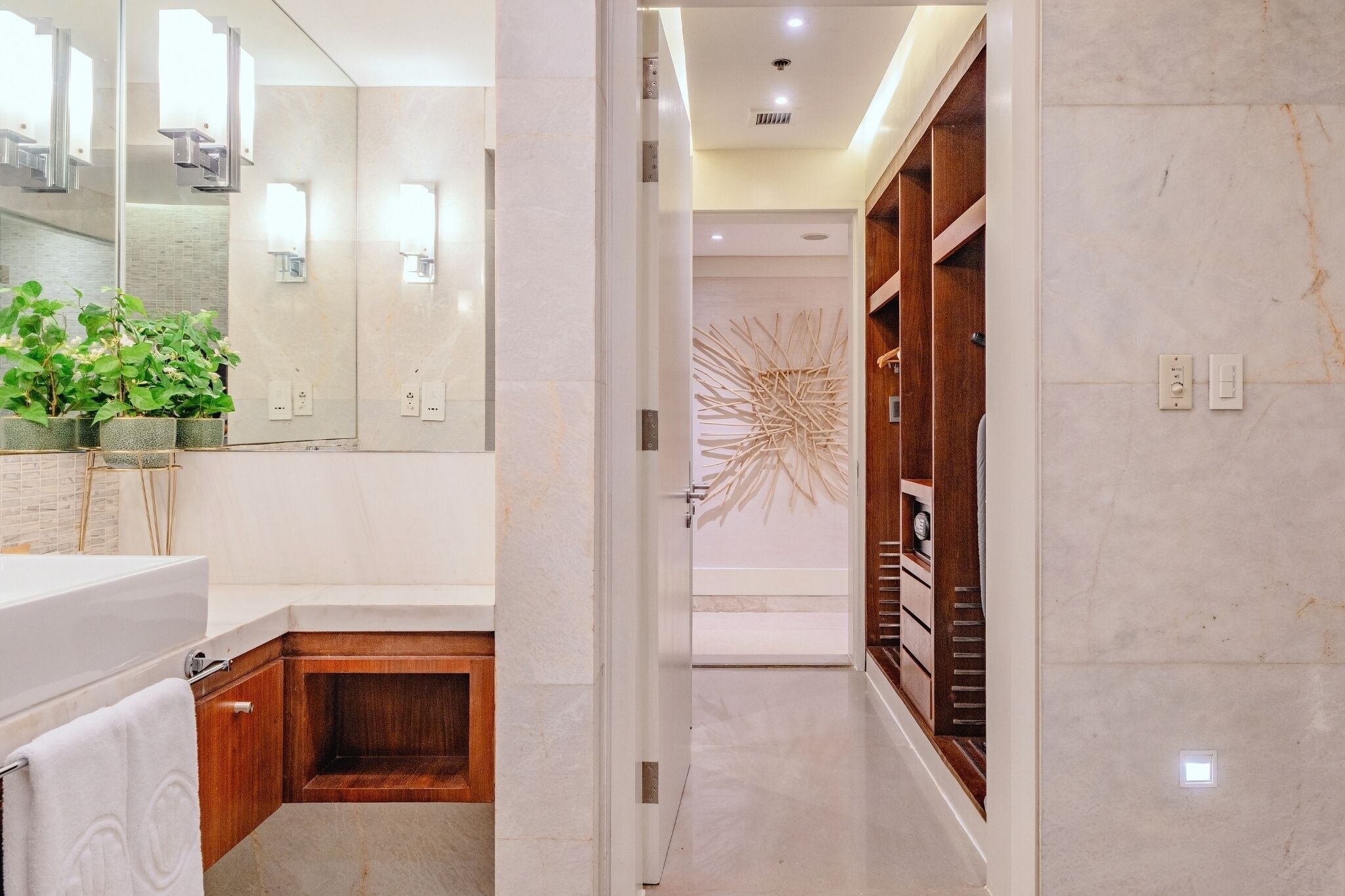 A modern bathroom with a large mirror, a bathtub, and a wooden vanity.