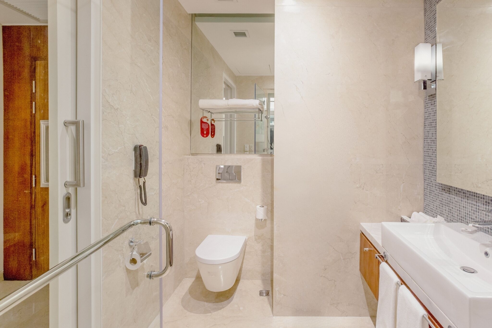 Ein modernes Badezimmer mit Duschkabine aus Glas, einer weißen Toilette und einem Waschbecken mit Spiegel.