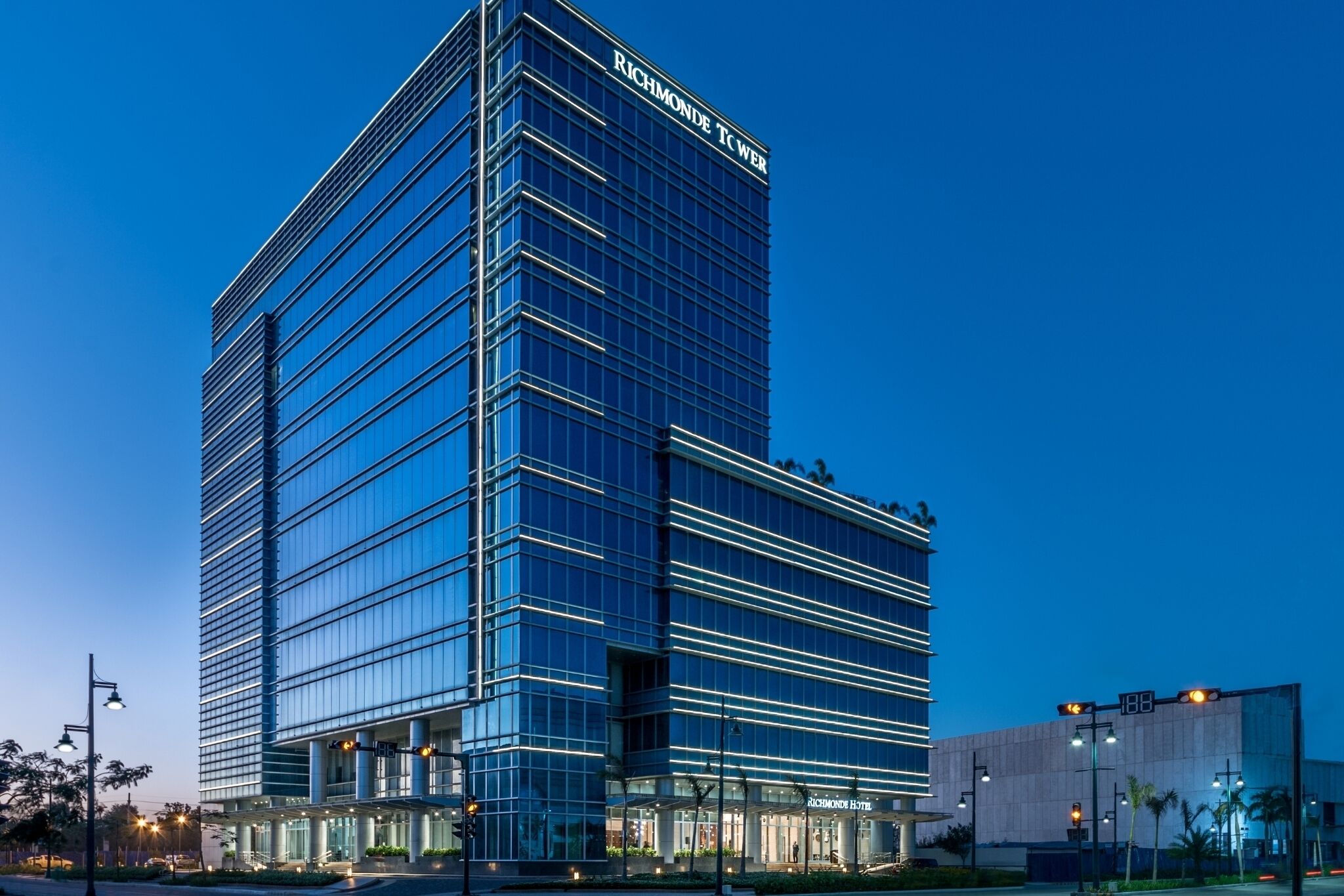 Un edificio alto y moderno con fachada de vidrio y el nombre "Richmond Tower" en la parte superior.
