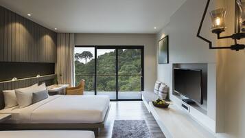 Una habitación de hotel moderna con dos camas, un televisor grande y un balcón con vistas al bosque.