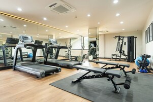 A gym with treadmills, a bench press, and weight machines.