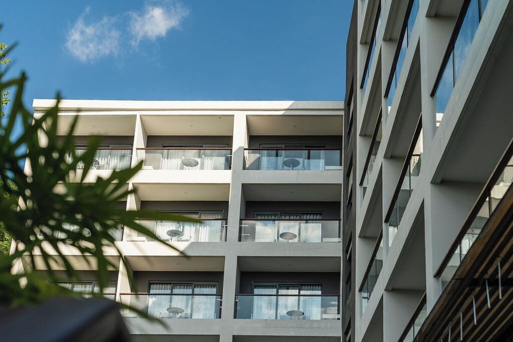 A multi-story building with balconies and large windows.