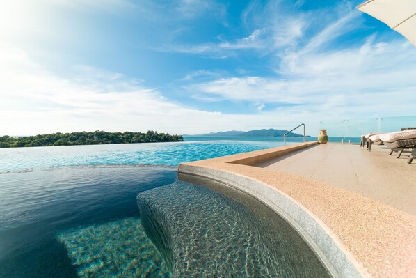 Outdoor pool, an infinity pool, pool umbrellas, pool loungers