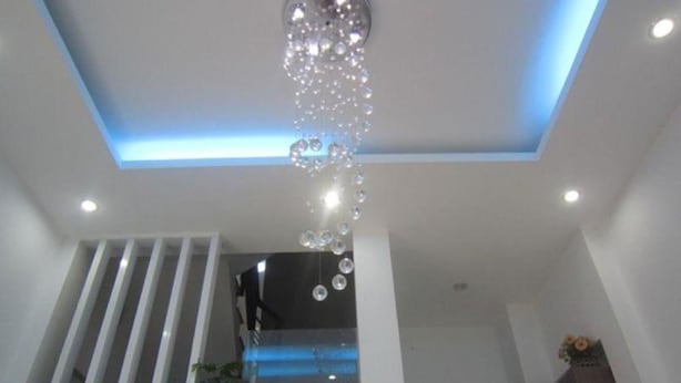 A modern interior with a staircase, a decorative hanging light fixture, and recessed ceiling lighting. - Saigon Inn Hotel (Ho Chi Minh City)