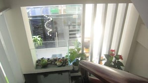 A room with a large window, a wooden railing, and a small table with decorative items. - Saigon Inn Hotel (Ho Chi Minh City)