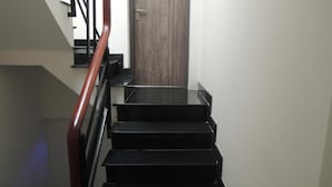 A staircase with black steps and a wooden door at the top. - Saigon Inn Hotel (Ho Chi Minh City)