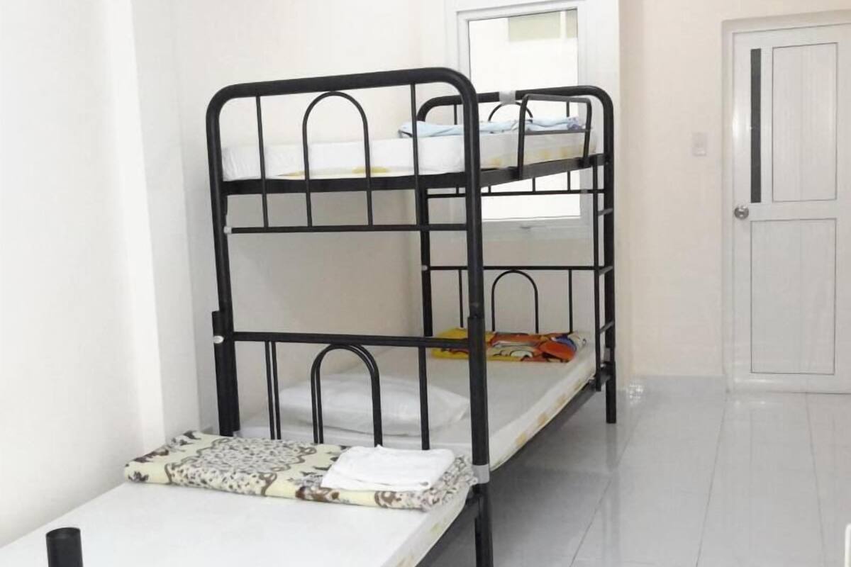 A bunk bed in a room with a white door and a window.