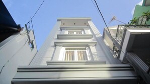 A building with a white facade, multiple windows, and a balcony with a metal railing. - Saigon Inn Hotel (Ho Chi Minh City)