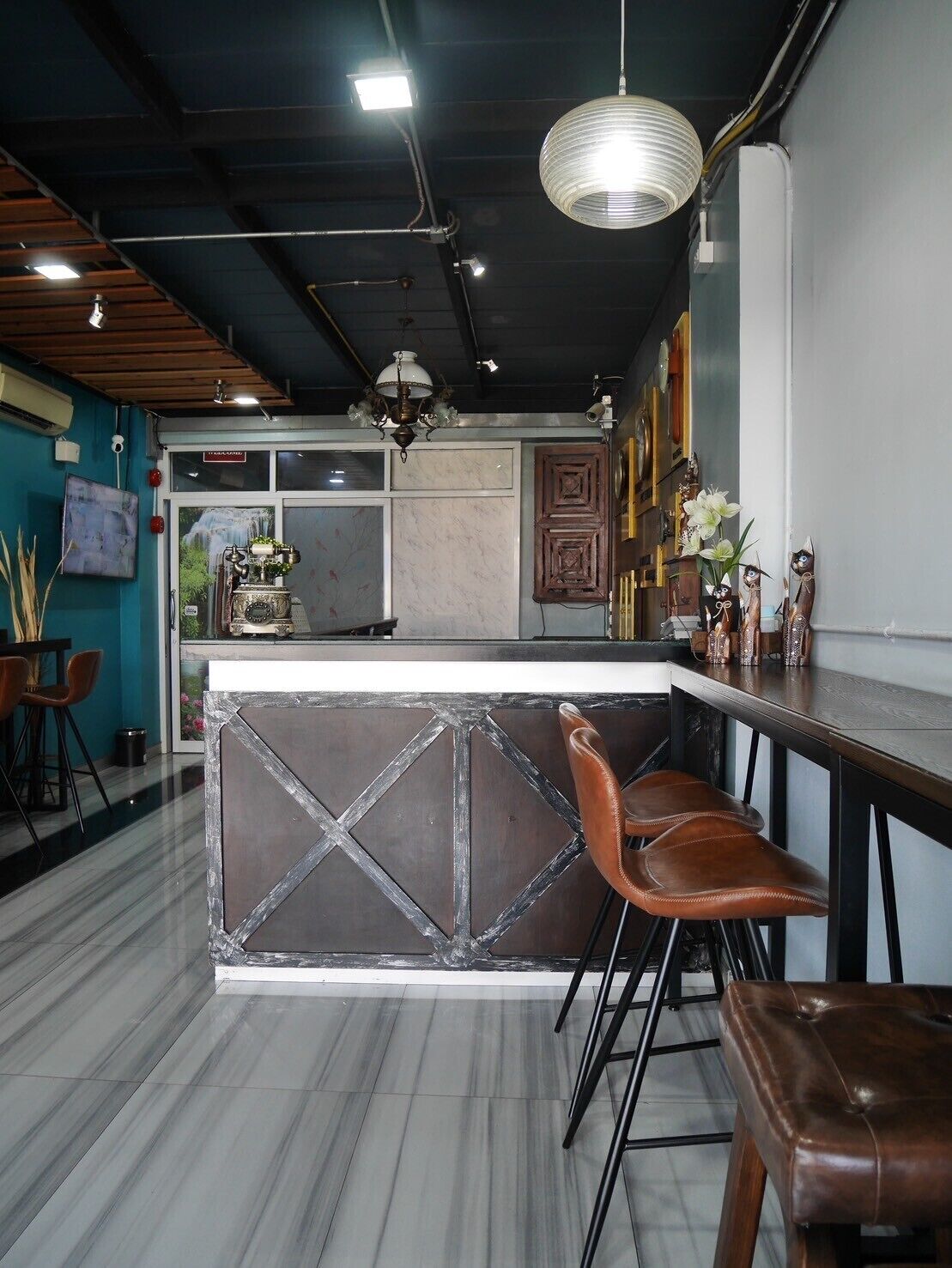 Eine moderne Bar mit einer Marmor-Theke, Leder-Bistrostühlen und einem dekorativen Kronleuchter.