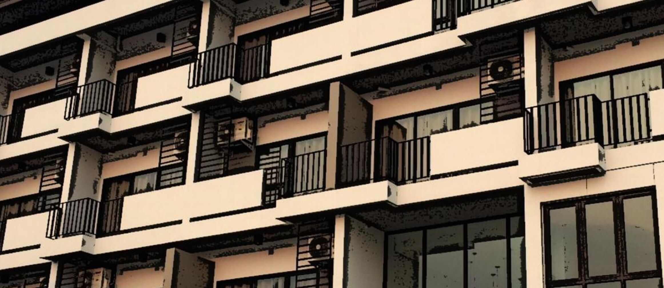 Un edificio de varios pisos con balcones y ventanas grandes.