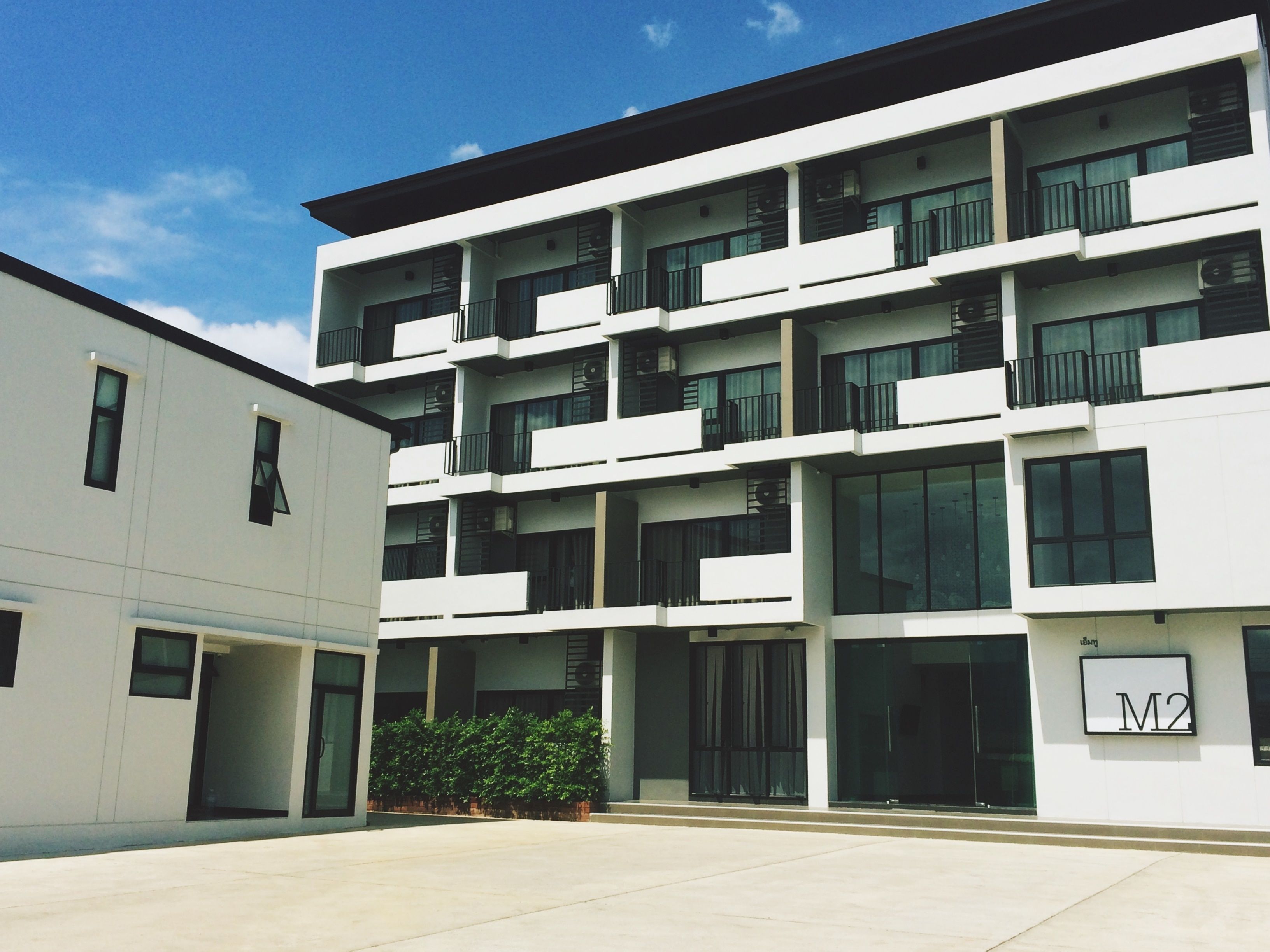 A modern multi-story building with balconies and large windows.