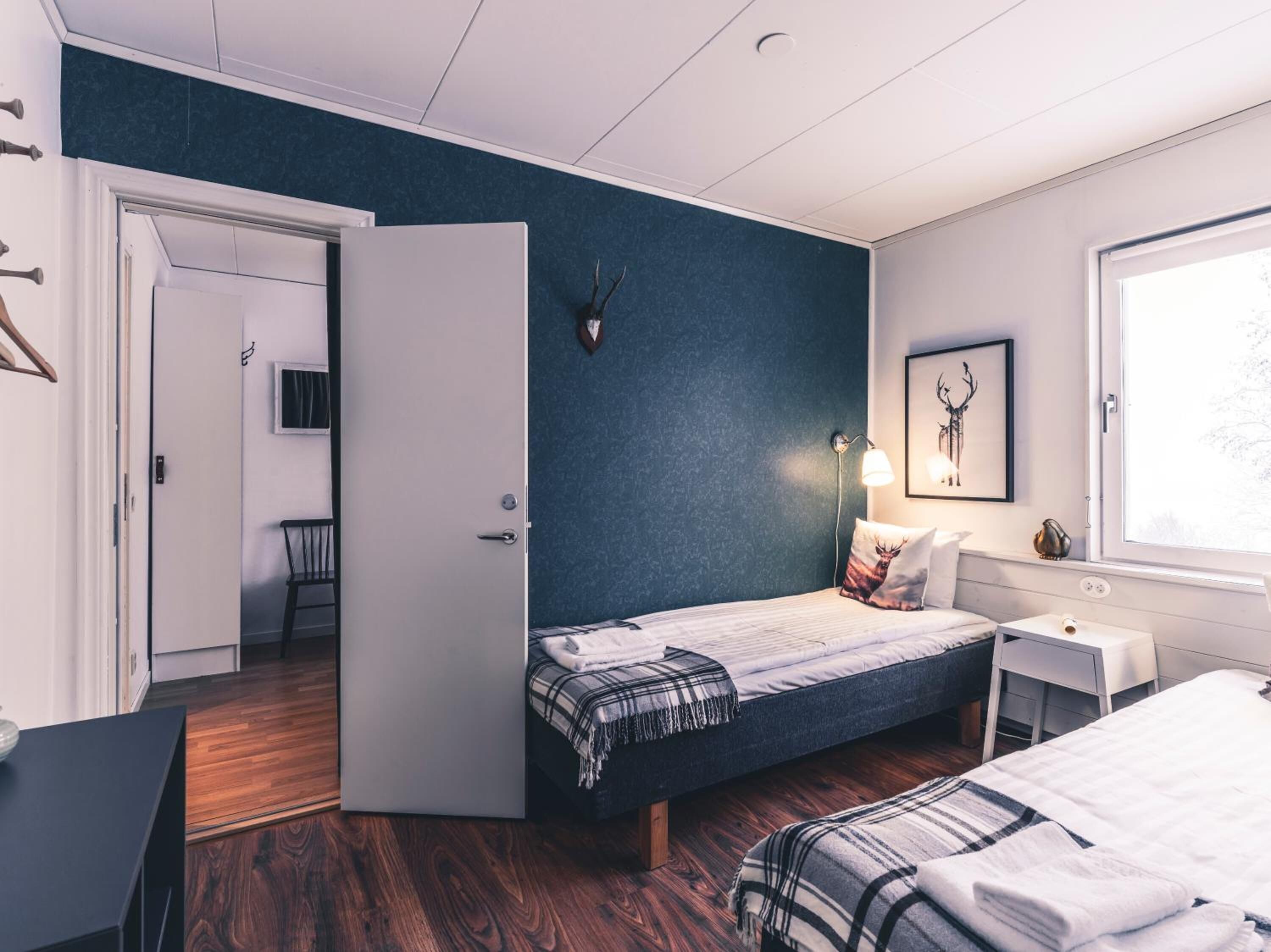 Een slaapkamer met een bed, nachtkastje en een raam.