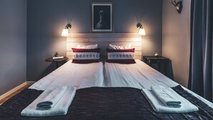 A neatly made bed with two pillows, a framed picture above, and two bedside lamps. - Åre Bed & Breakfast (Are)