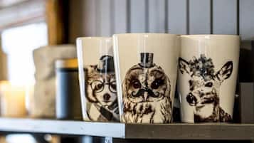 Three ceramic mugs with animal designs on a shelf.