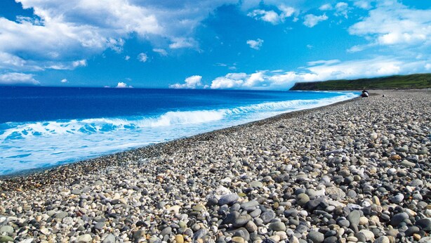 A pebbled beach with waves crashing onto the shore under a clear sky. - Ola Hotel (Hualien City)