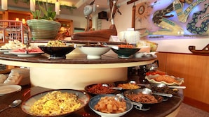 A buffet with various dishes and a decorative wall with artwork. - Ola Hotel (Hualien City)