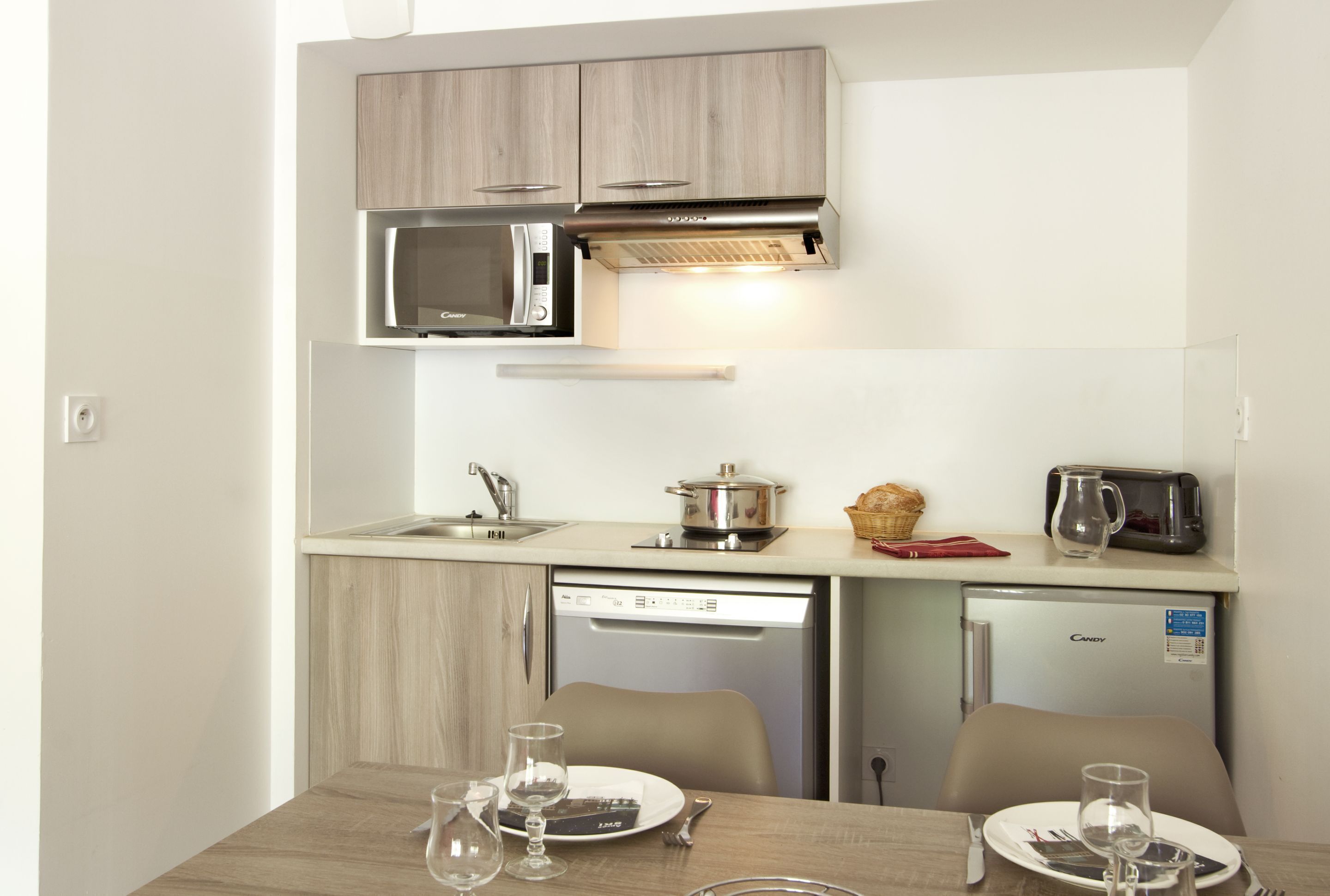Eine kleine Küchenzeile mit Mikrowelle, Toaster und kleinem Kühlschrank.