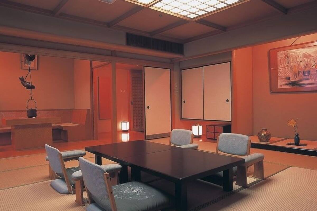 A traditional Japanese-style room with tatami flooring, a low table, and shoji screens.
