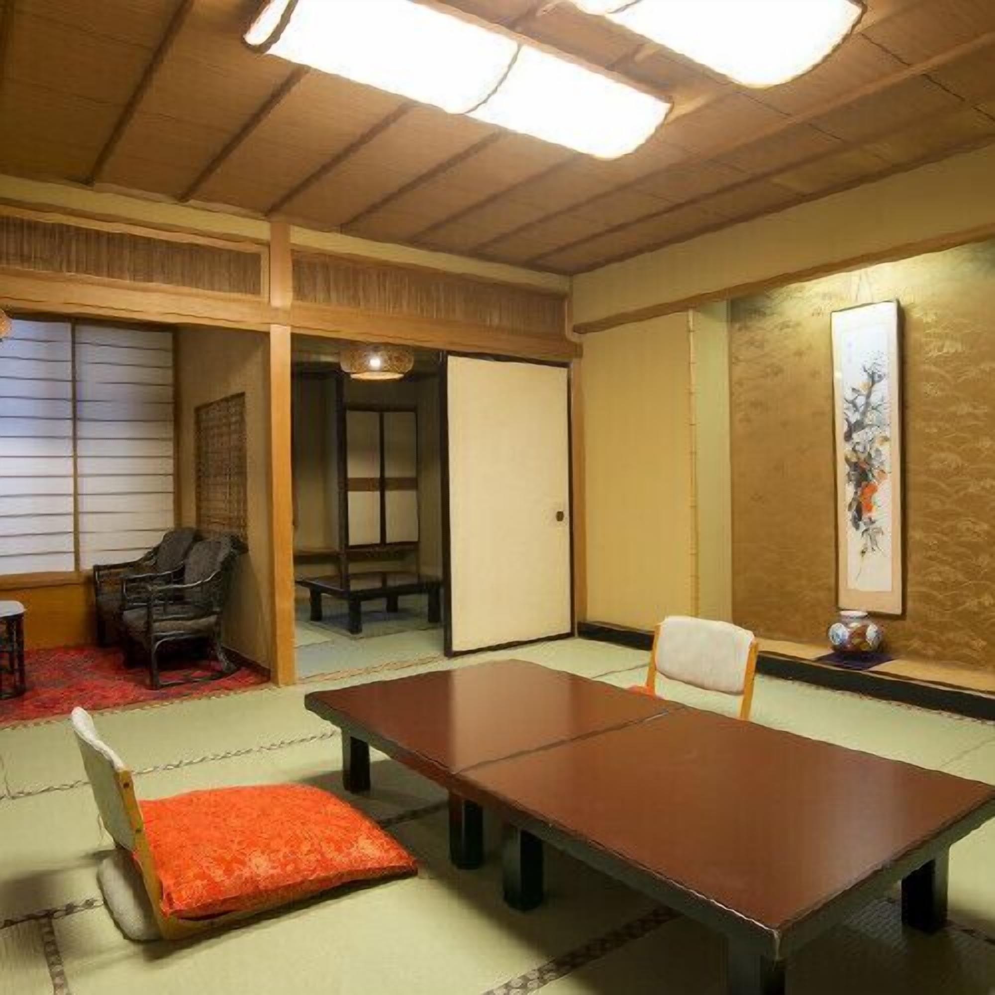 Um quarto japonês tradicional com tatames, uma mesa baixa e uma porta deslizante que dá para outro cômodo.