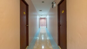 A hallway with two doors, each marked with a number. The floor is tiled, and the walls are painted in a light color. - Mukanda Residence (Krabi)