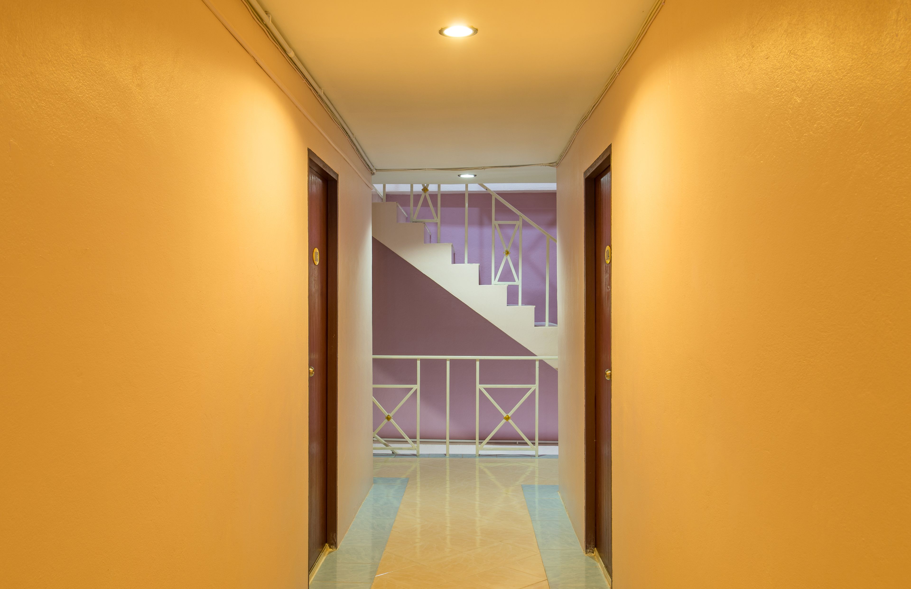 A hallway with a staircase leading to a landing.
