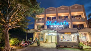 A multi-story building with a neon sign reading "Mukanda Residence." - Mukanda Residence (Krabi)