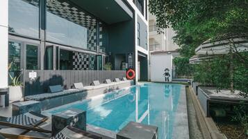 Alberca al aire libre y camastros