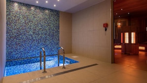 A modern spa area with a mosaic-tiled wall, a small pool, and a wooden reception desk. - Résidence Odalys Edenarc - Arc 1800 (Bourg-Saint-Maurice)
