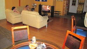 Un soggiorno con un divano, una televisione e un tavolino con piano in vetro.