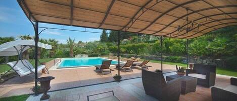 Alberca al aire libre y camastros