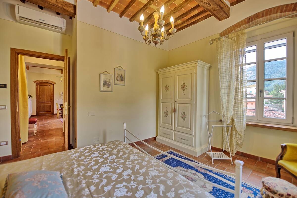 A bedroom with a bed, wardrobe, and a window with a view.