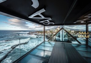 A modern interior with a glass floor overlooking the ocean, a geometric ceiling design, and the text "SAAJ MAAR" visible. - Silken Saaj Maar- Adults Only (Puerto de la Cruz)