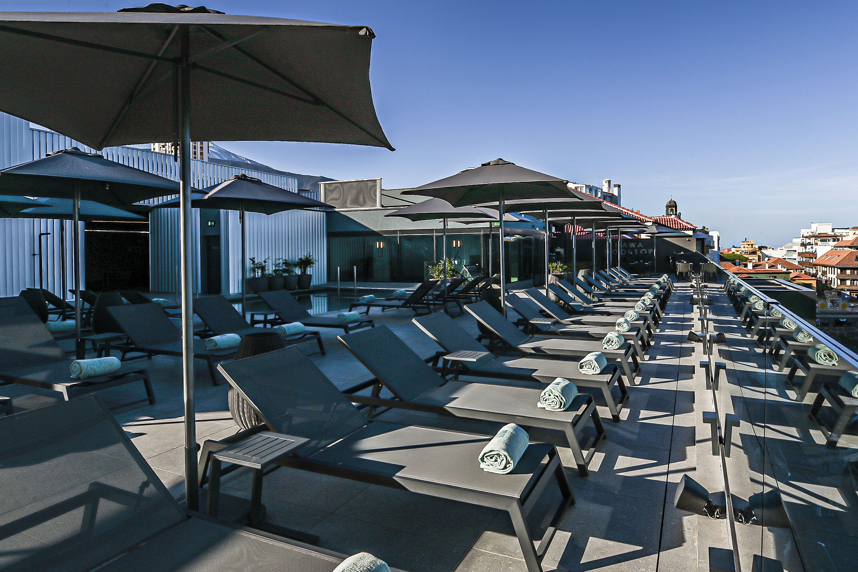 Een buitenzwembad, parasols voor strand/zwembad