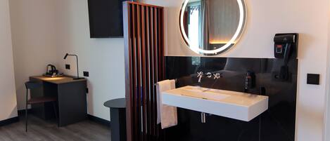 A modern bathroom with a vanity, sink, and mirror.