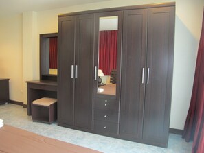 A bedroom with a large wardrobe, a desk, and a bed. - Rouge Service Apartments (Pattaya)