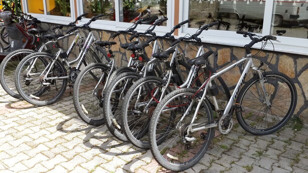 A row of bicycles parked against a stone wall. - Canada Hotel & Bungalows (Kemer)