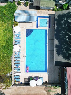 Piscine extérieure, parasols de plage, chaises longues