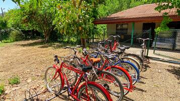 Bicycles parked in an outdoor area with a building in the background.