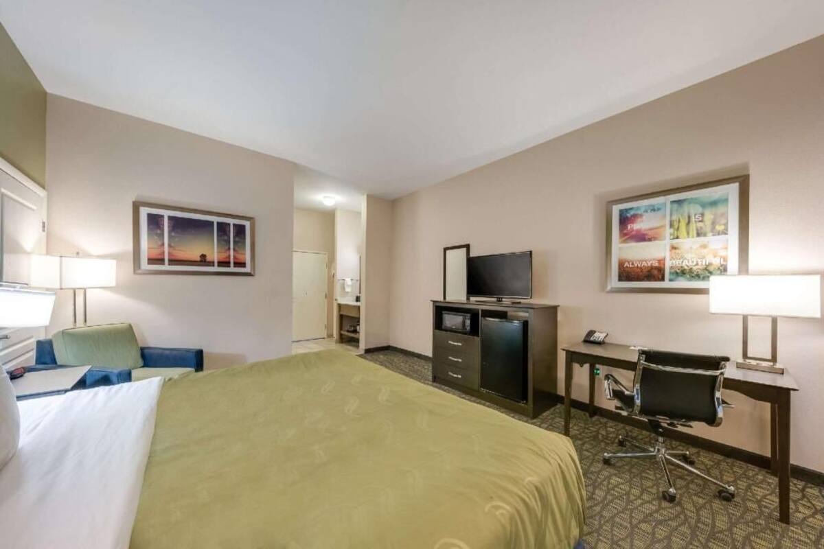 Une chambre d’hôtel équipée d’un lit, d’un bureau, d’une télévision et d’une chaise.